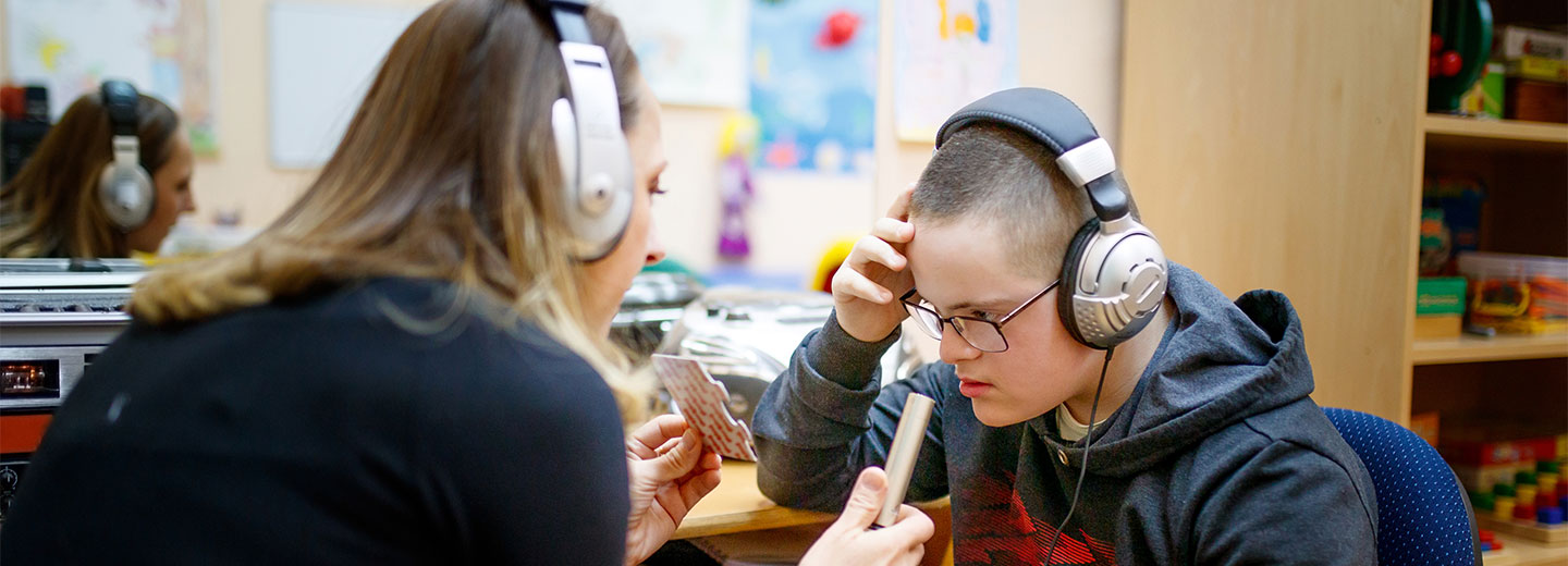 teacher working with student in hearing lab